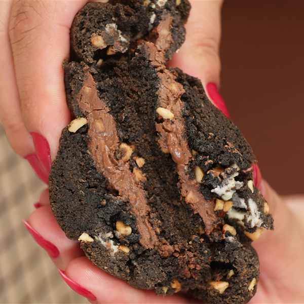 Cookie Ferrero de cacau black partido ao meio, com recheio de creme de avelã
